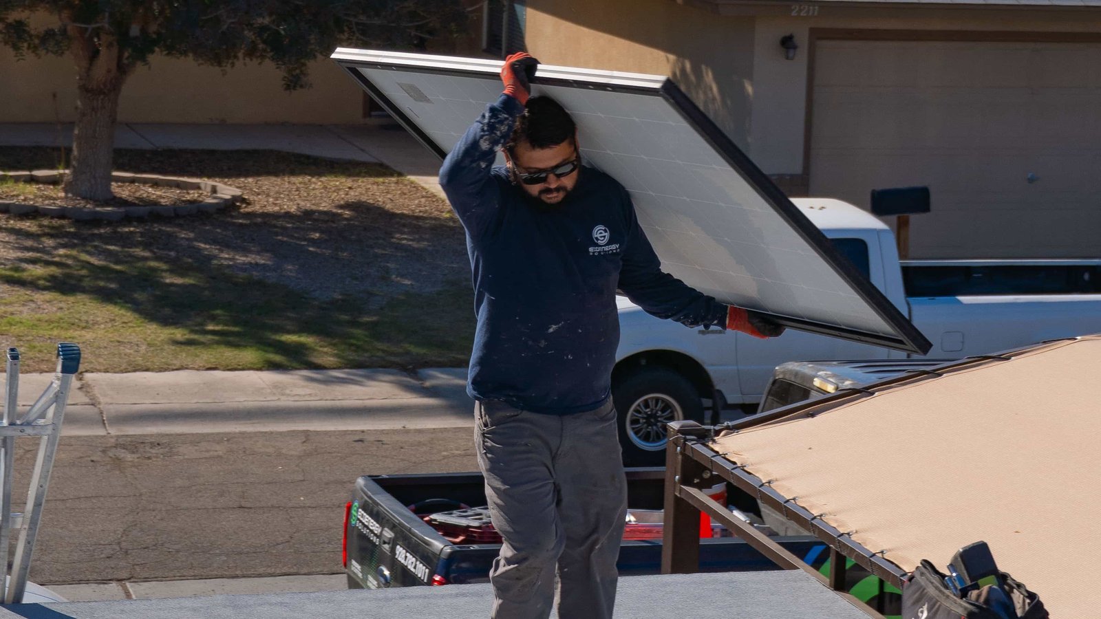 EcoEnergy technician carrying solar panel